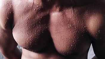 Close up into the sweat over flexing body